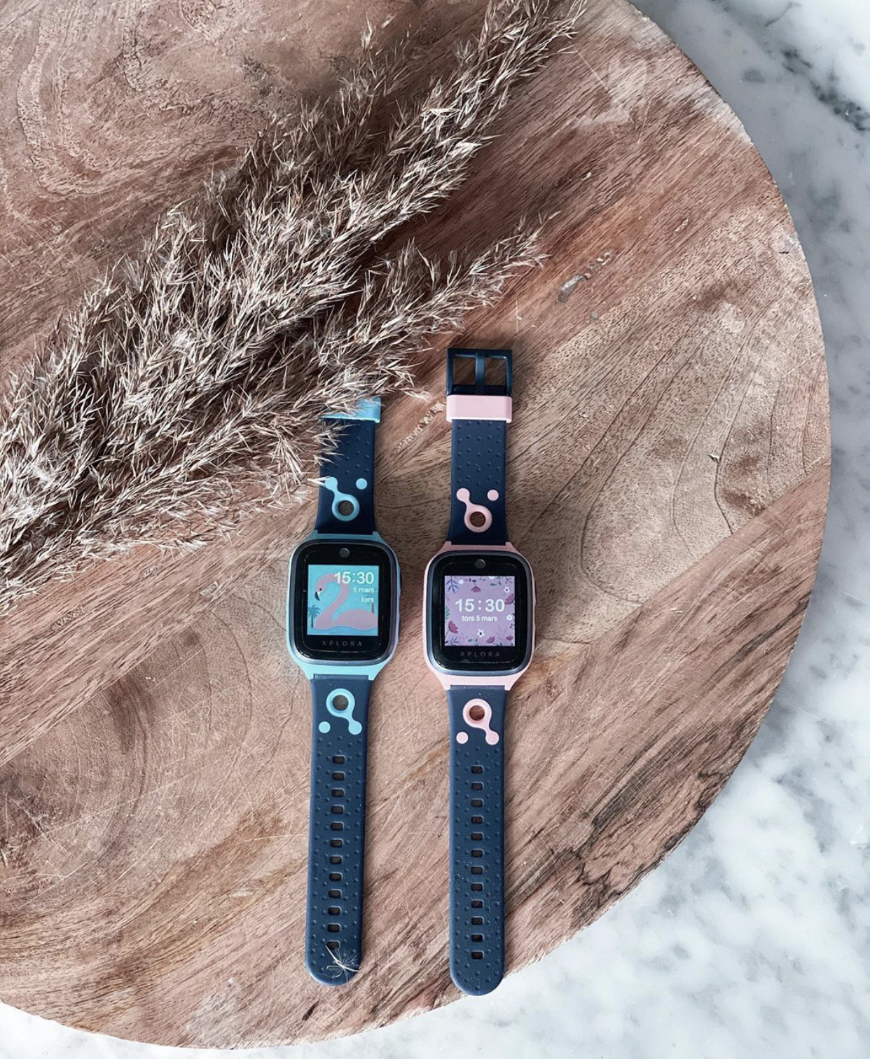 to smartklokker på et bord. En er grønn og en er rosa